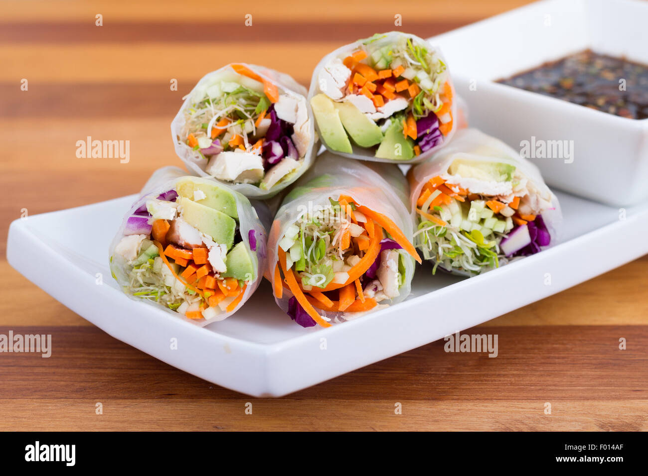 colourful chicken, sprouts and avocado rice paper spring rolls with soy