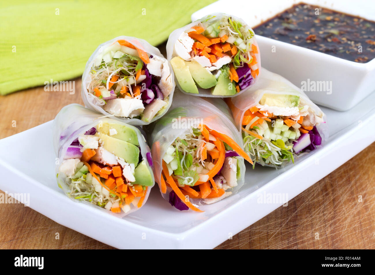 colourful chicken, sprouts and avocado rice paper spring rolls with soy base dip sauce Stock Photo