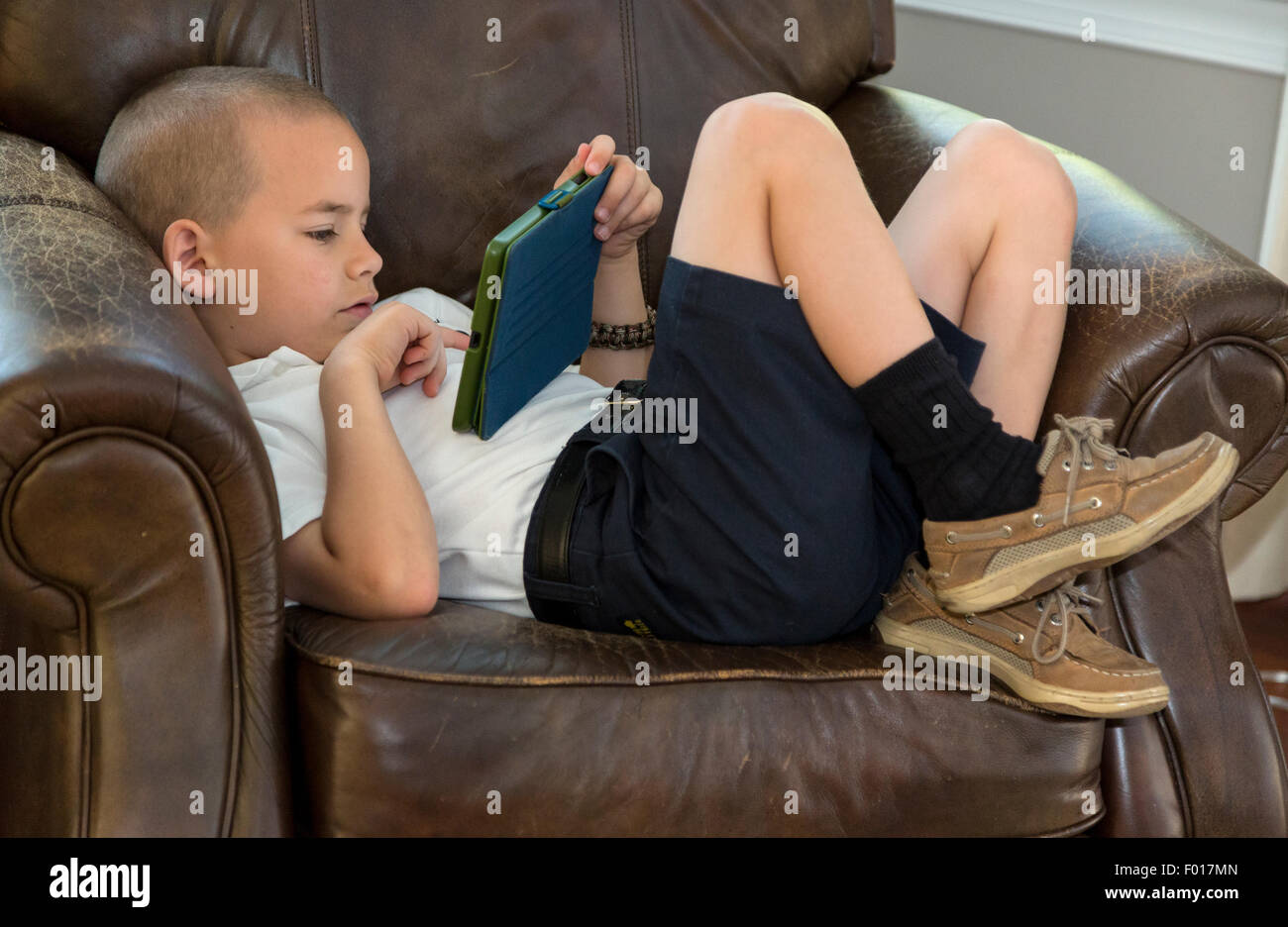 Young Boy (Seven Years Old) Playing a Video Game on his iPad.MR Stock Photo