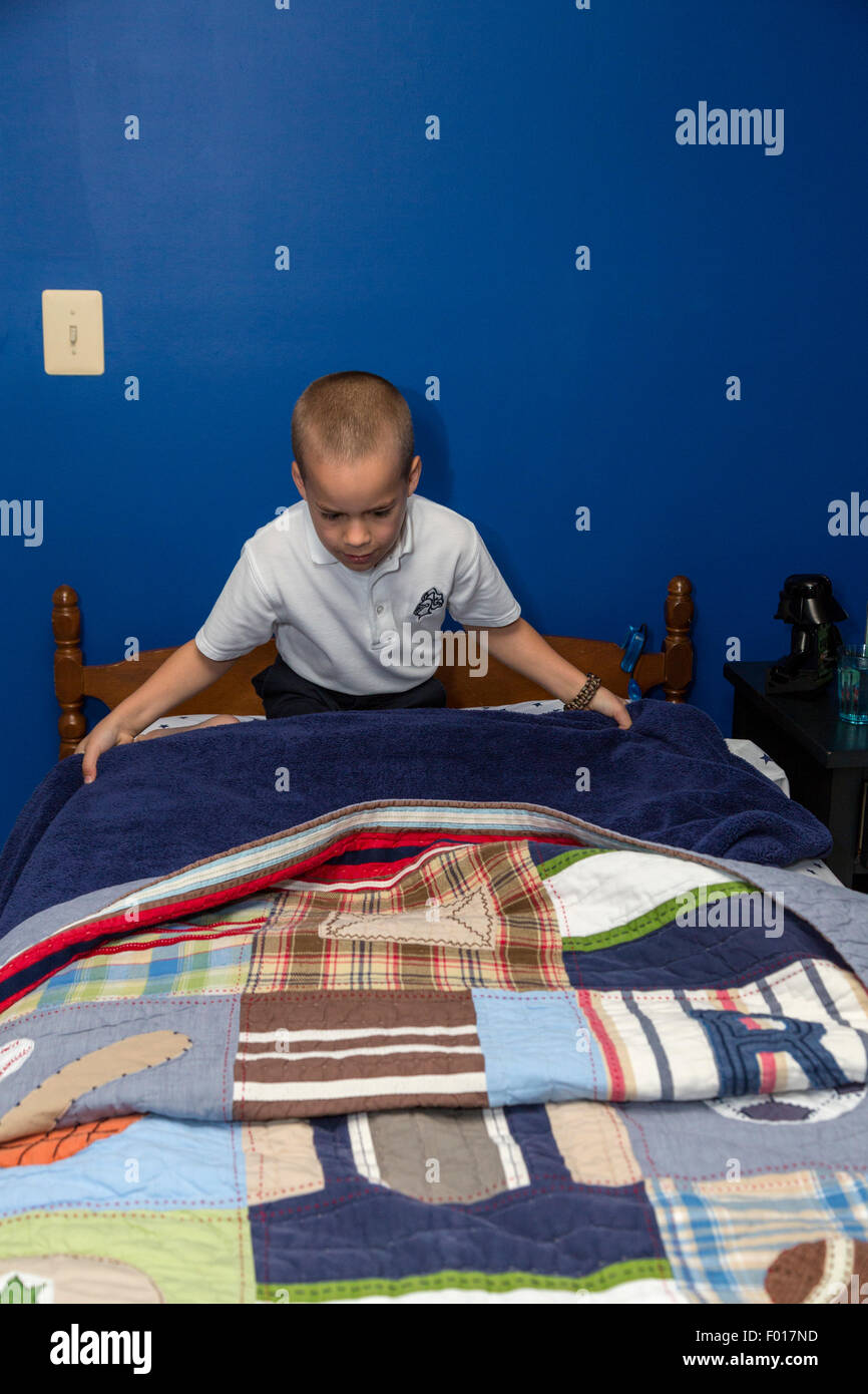 Young Boy (Seven Years Old) Making His Bed in the Morning.  MR Stock Photo