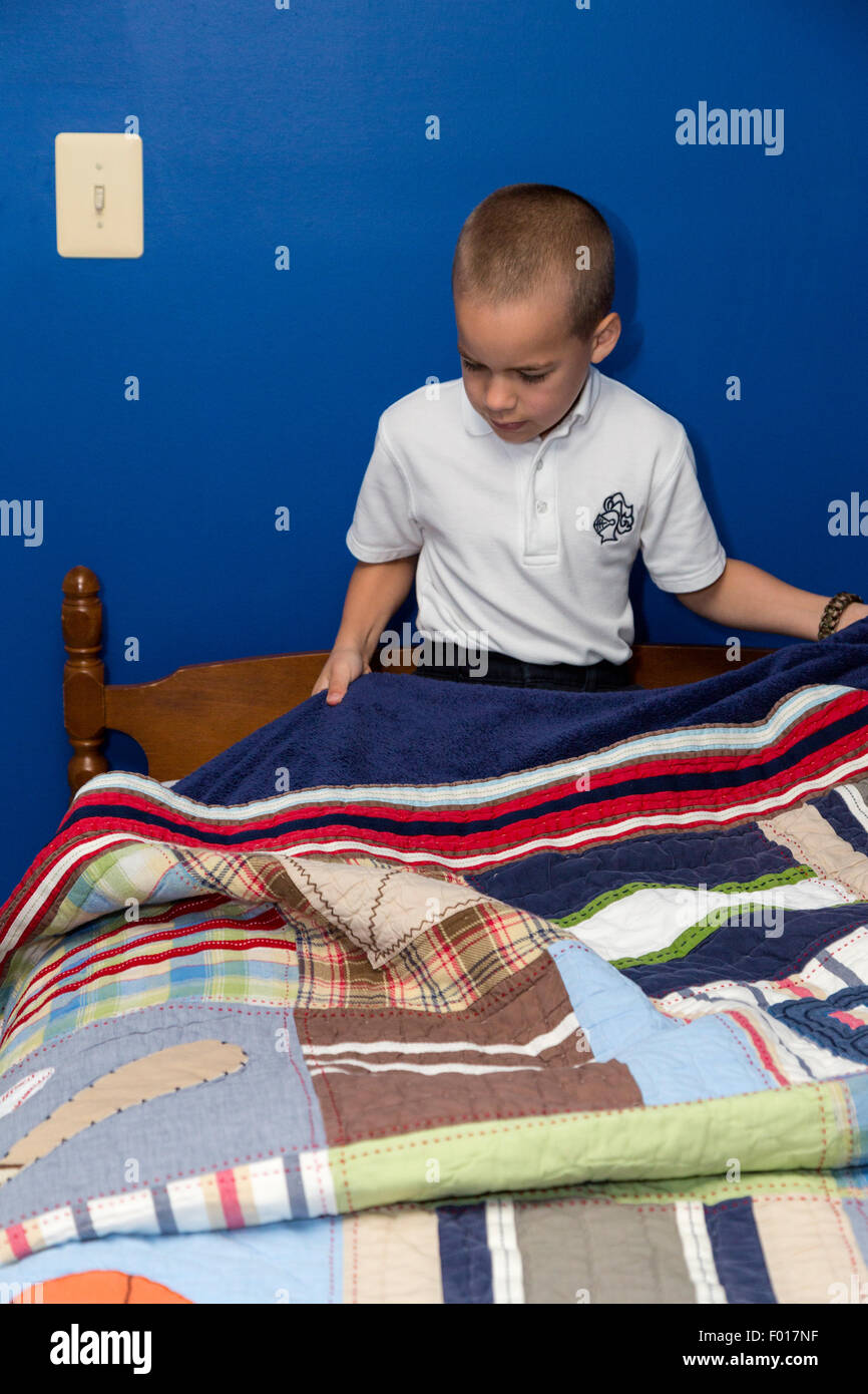 Young Boy (Seven Years Old) Making His Bed in the Morning.  MR Stock Photo
