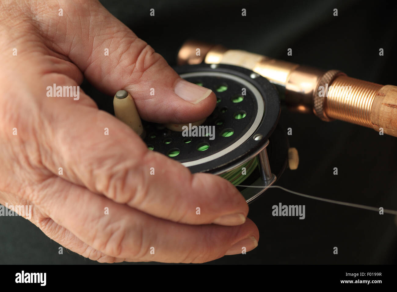 closeup view of a man's hand on his fishing reel Stock Photo