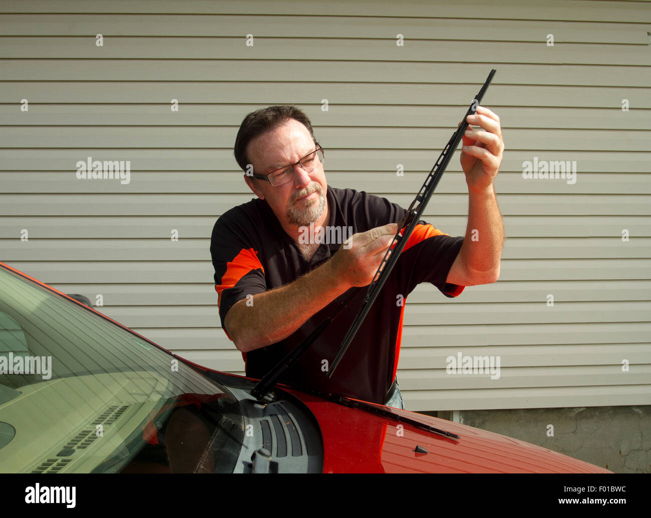 Mechanic changing windshield wipers on a crossover SUV. Stock Photo