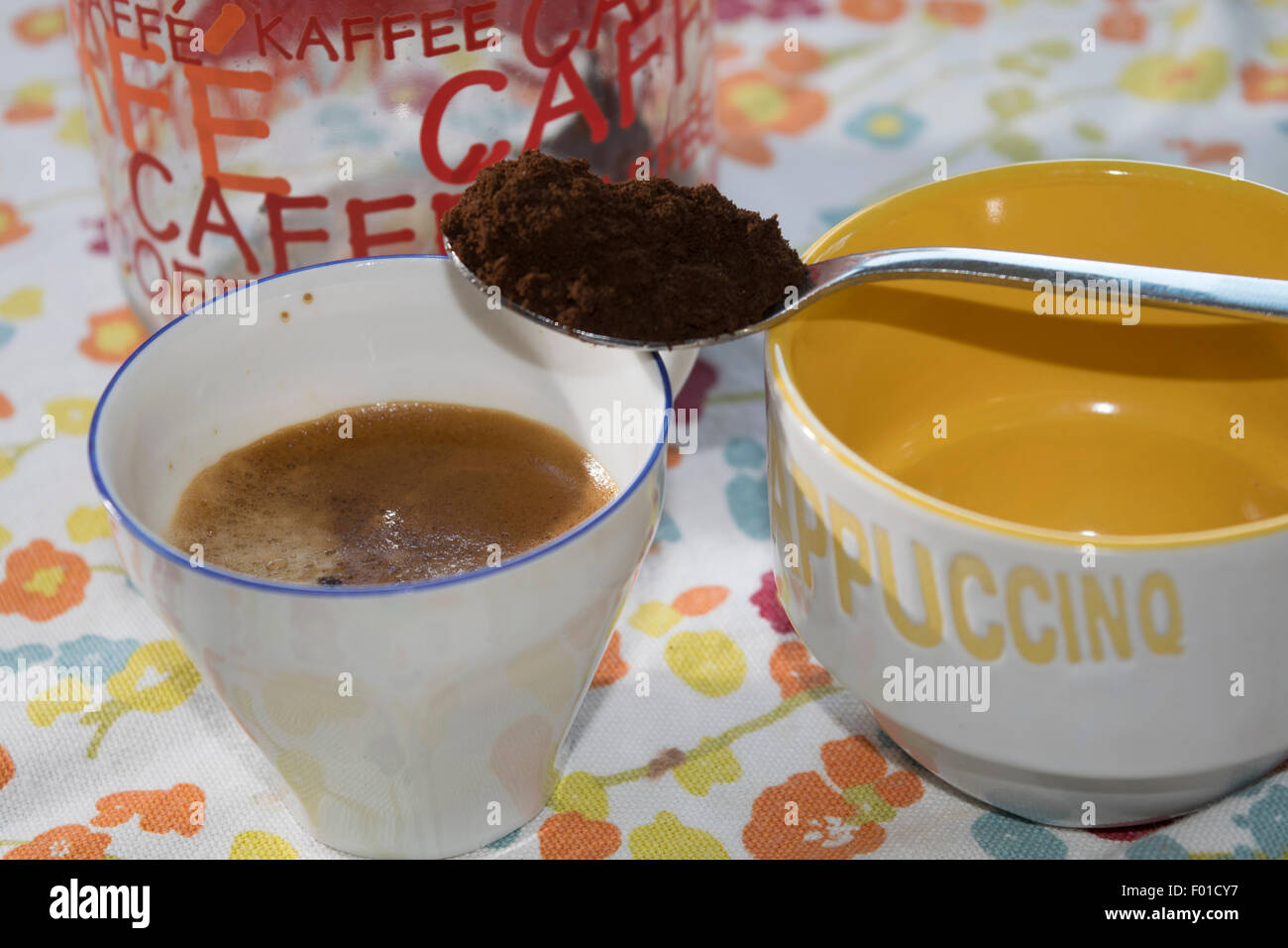 a cup of extra strong coffee with a teaspoon of ground coffee Stock