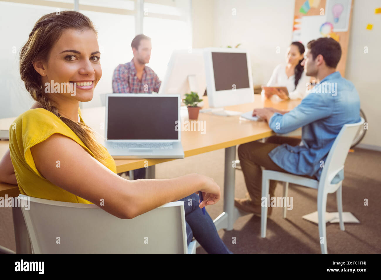 Smiling business team working on laptops Stock Photo - Alamy