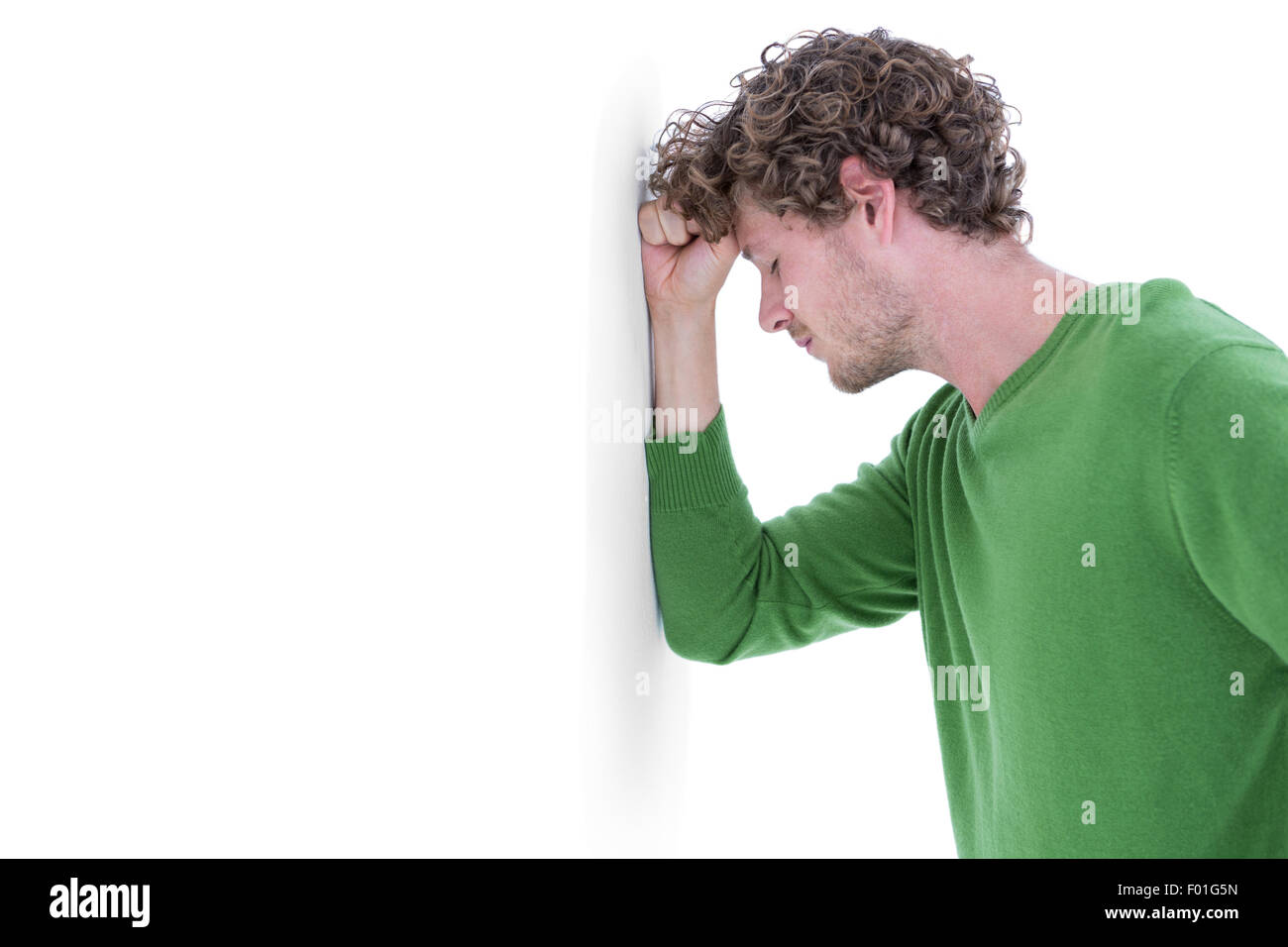 Sad casual man leaning against wall Stock Photo