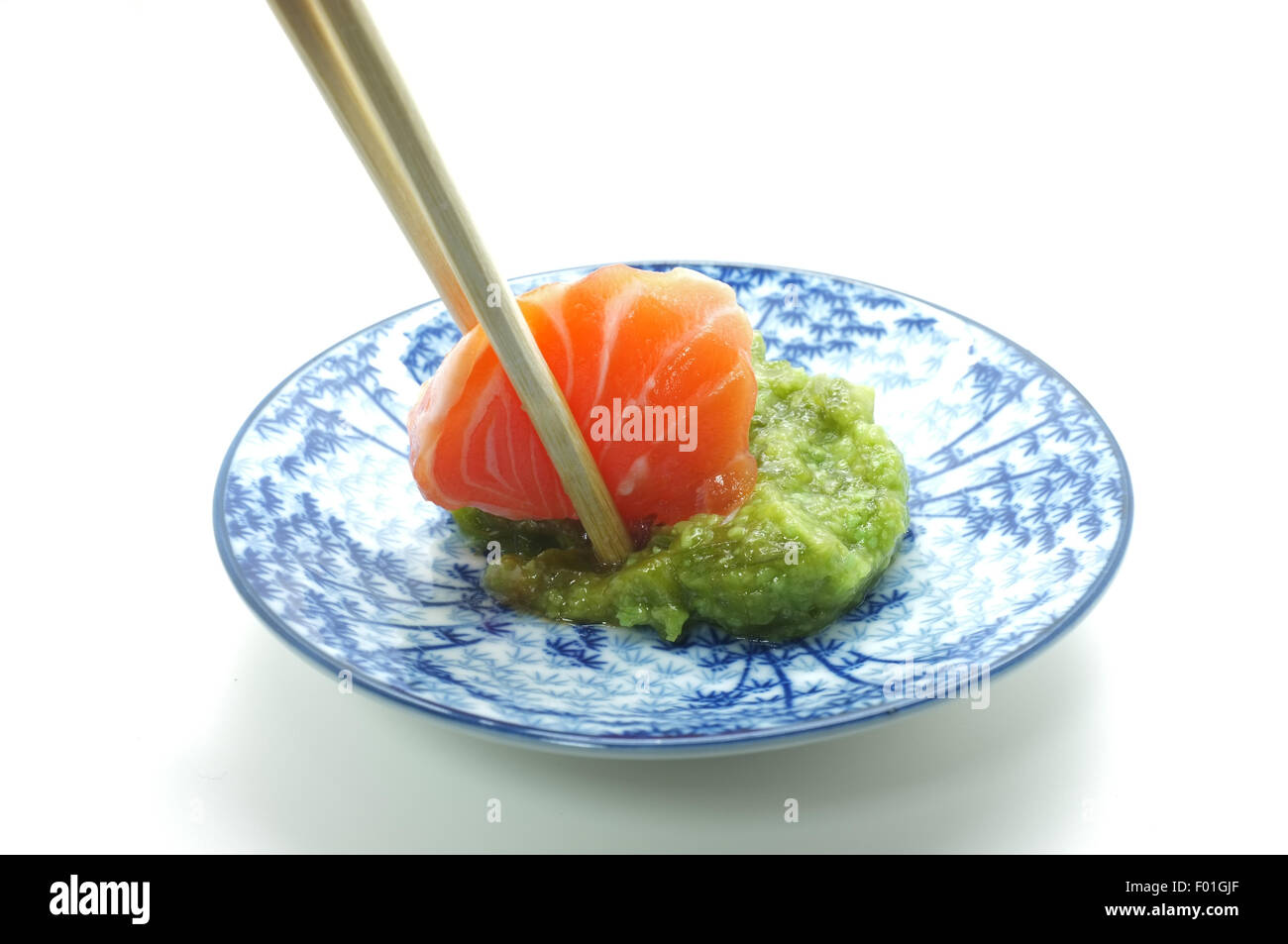 Chopsticks pinch fresh salmon sushi and wasabi Stock Photo