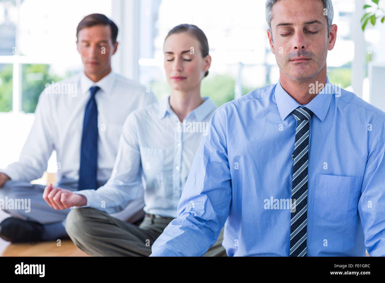 Business people doing yoga on floor Stock Photo - Alamy