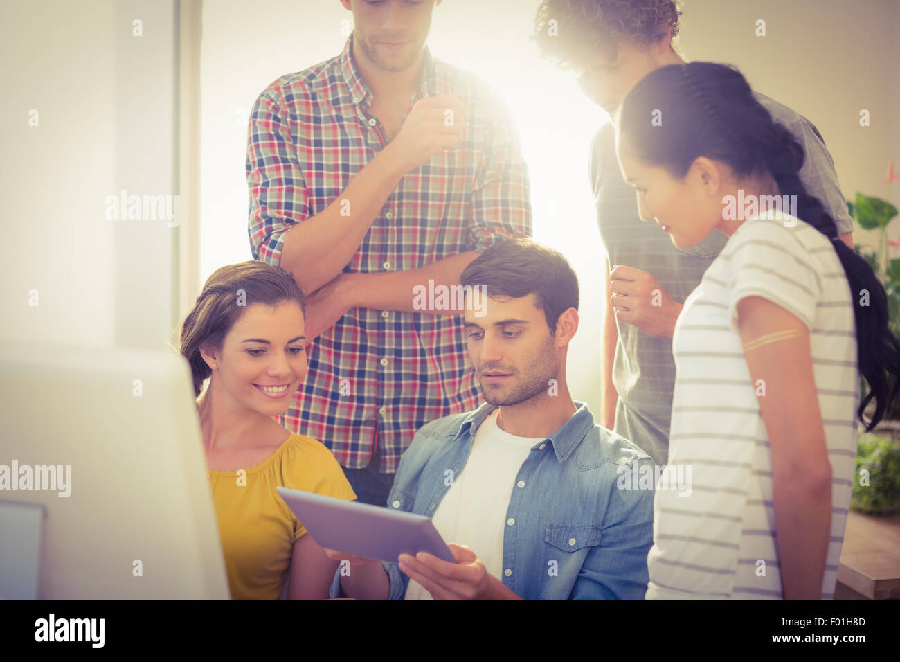 Creative business team gathered around a tablet Stock Photo - Alamy