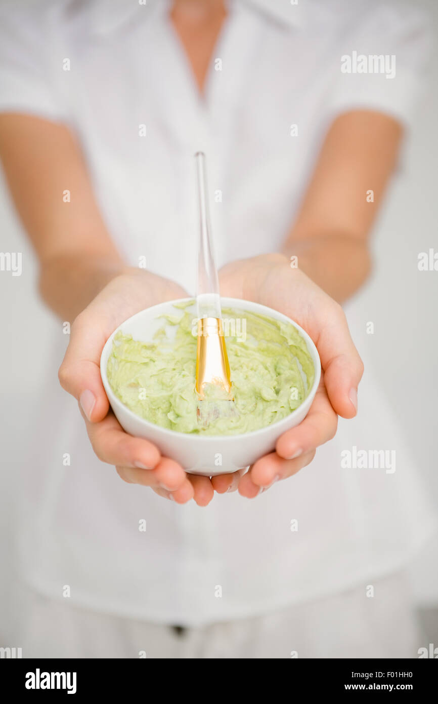 Woman having green cream to do a massage Stock Photo