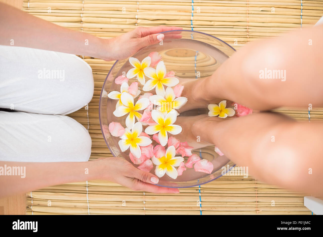 woman washing her feet in a bowl of flower Stock Photo