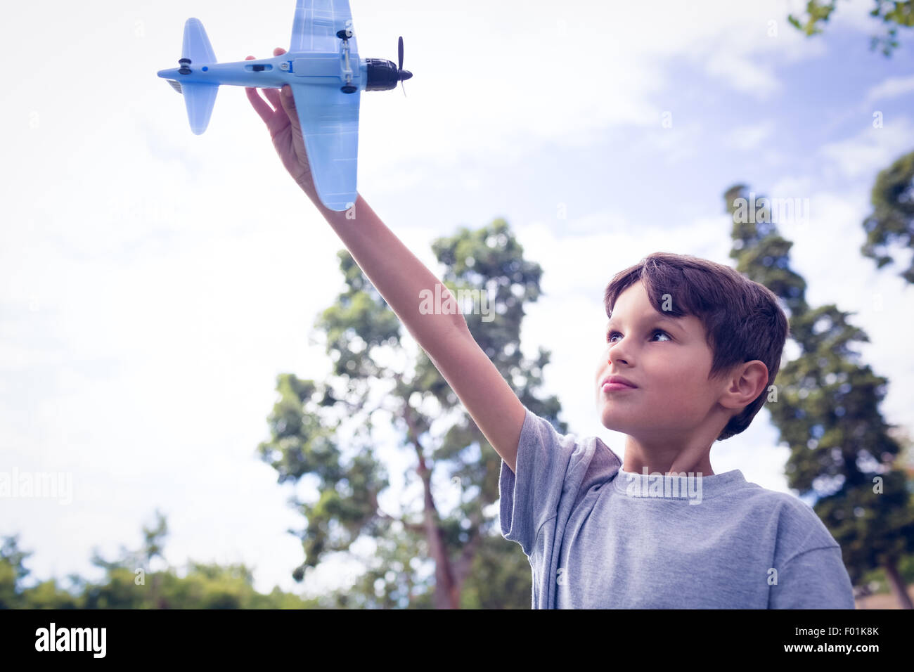 Boy playing with a toy plane at park Stock Photo - Alamy