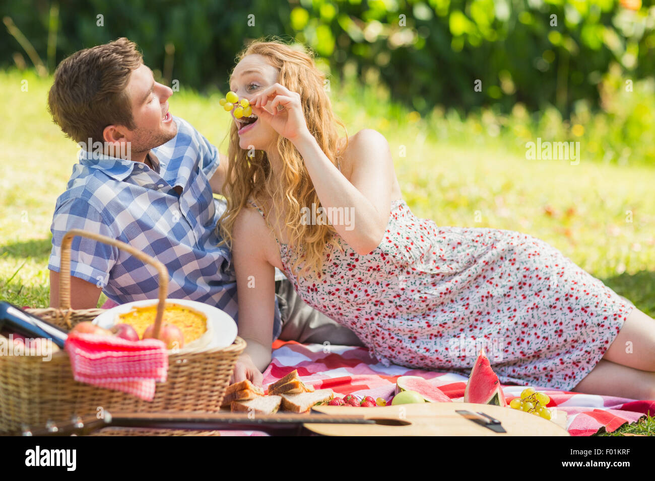 Young couple eating grapes at a picnic Stock Photo