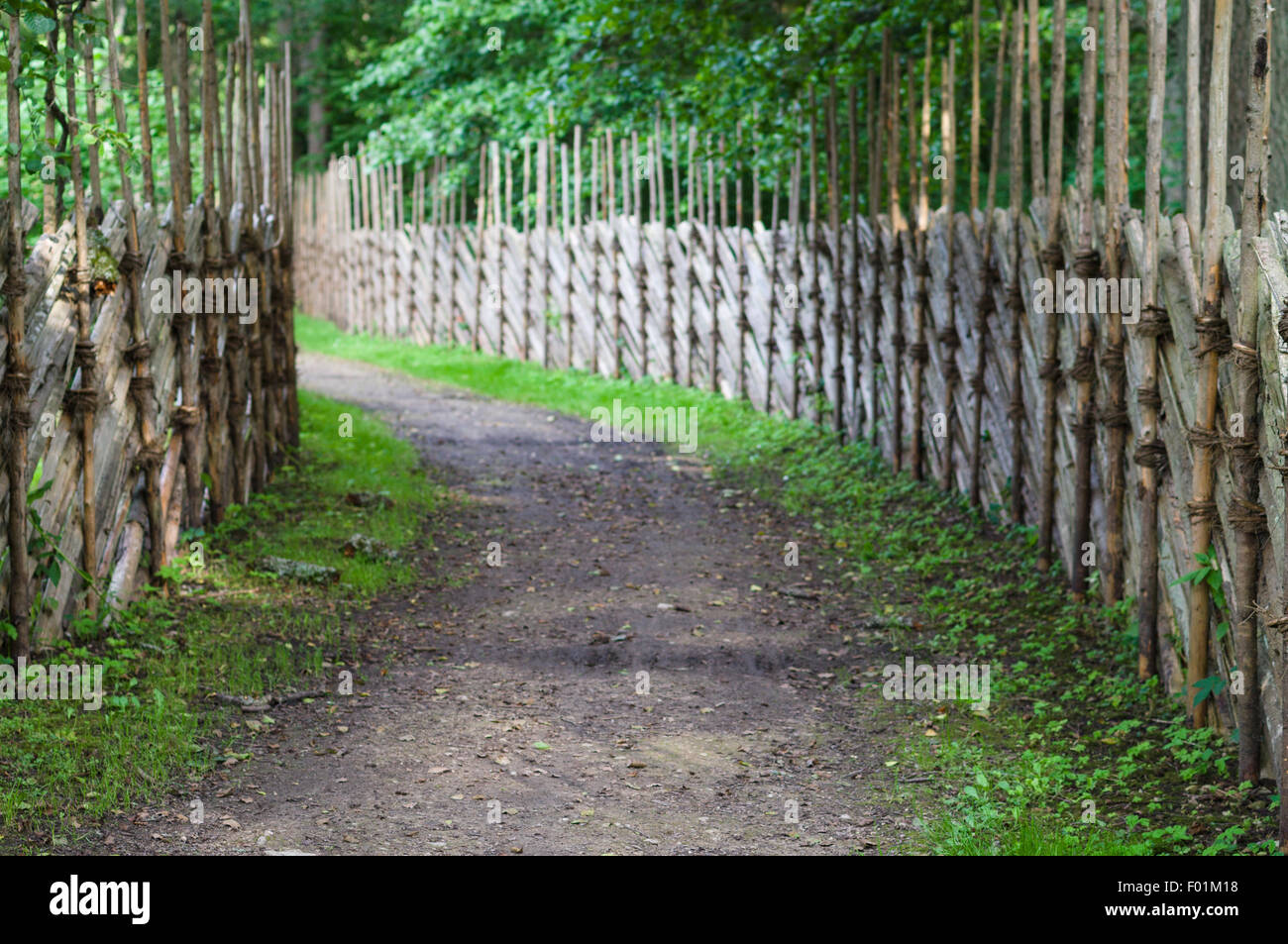 Defocused background of turning footpath between decorative wooden fences Stock Photo