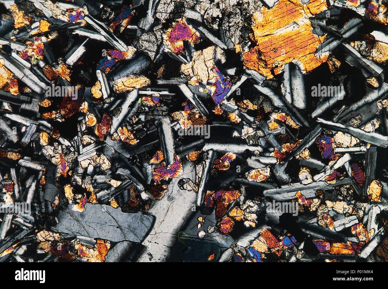 Basalt with plagioclase crystals and pyroxene. 55X magnification, using crossed Nicols. Stock Photo