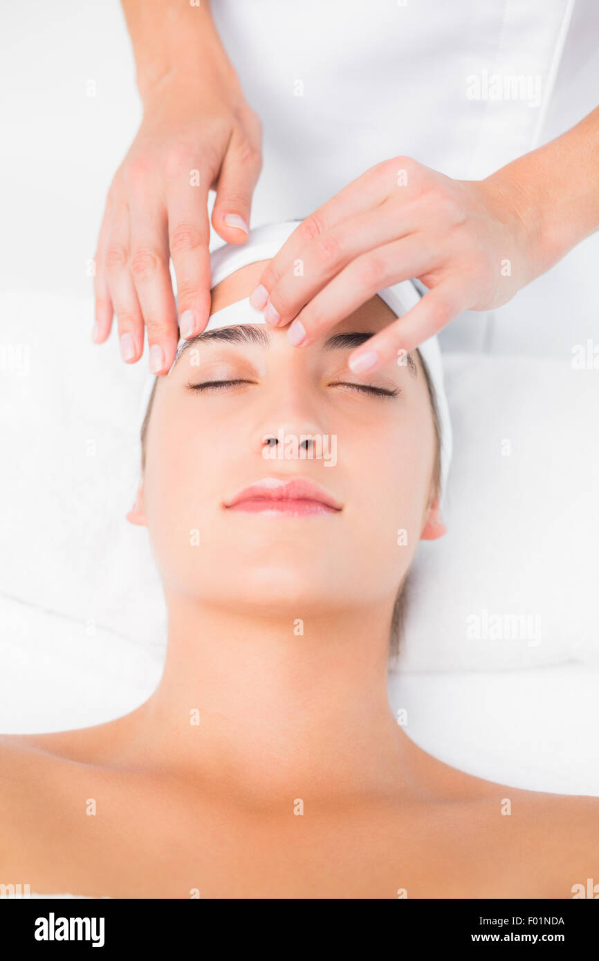 Hand waxing beautiful womans eyebrow Stock Photo