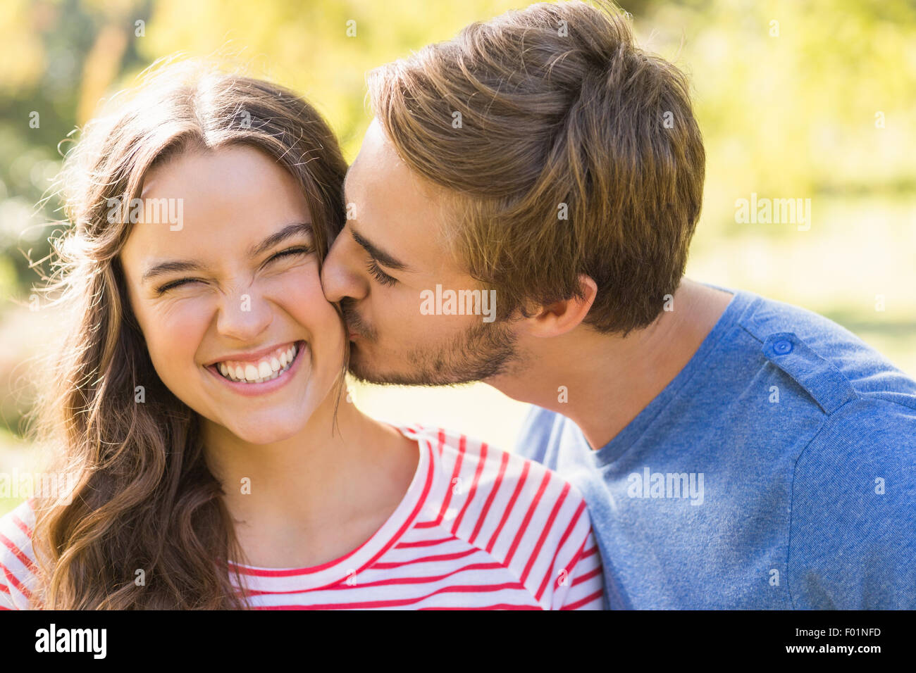 Cute couple kissing in the park Stock Photo Alamy