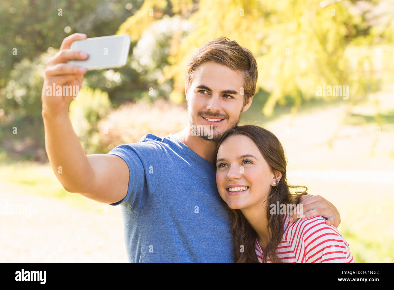 Cute couple doing selfie in the park Stock Photo - Alamy