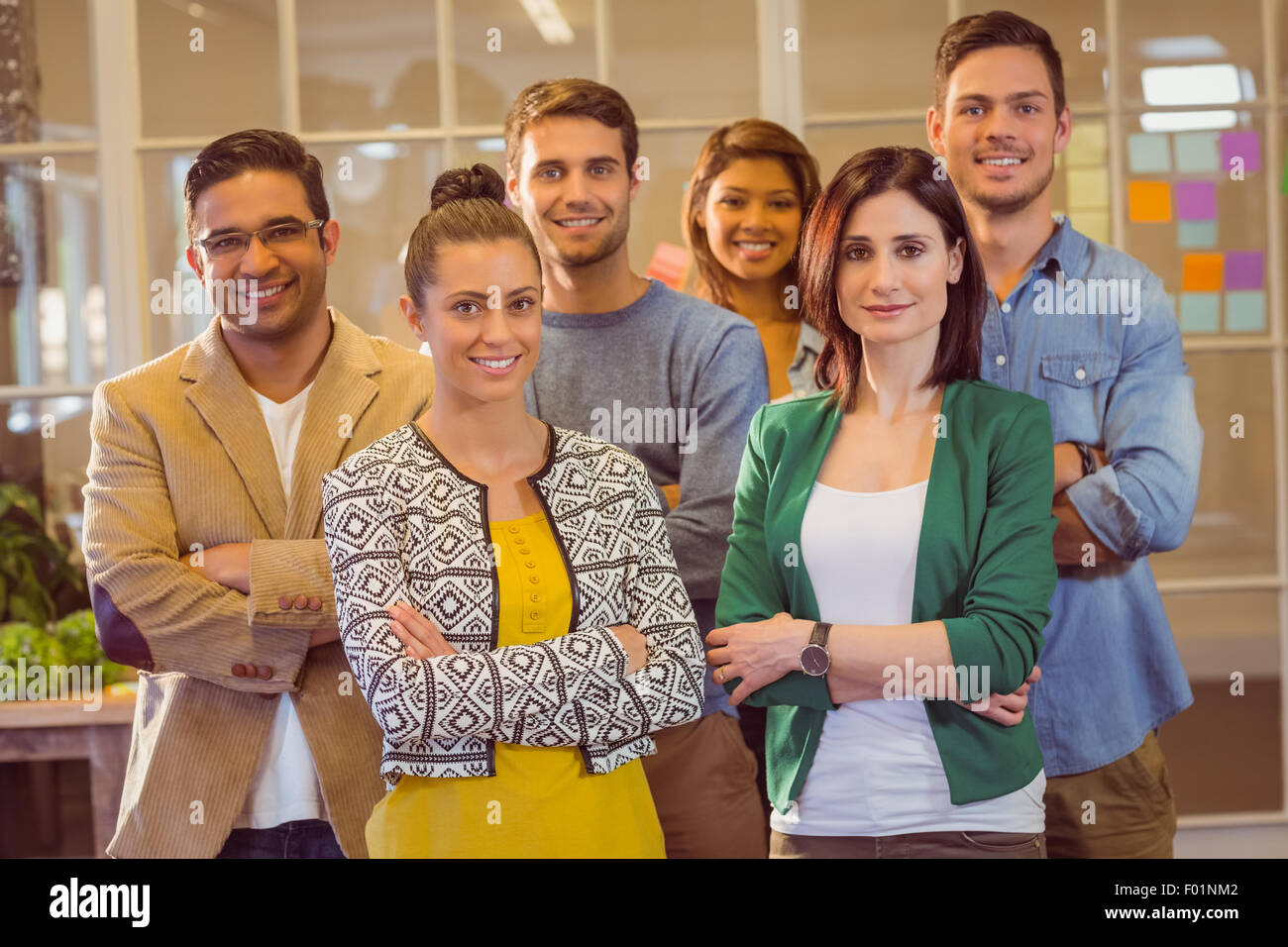 Happy business team smiling at camera with arms crossed Stock Photo - Alamy