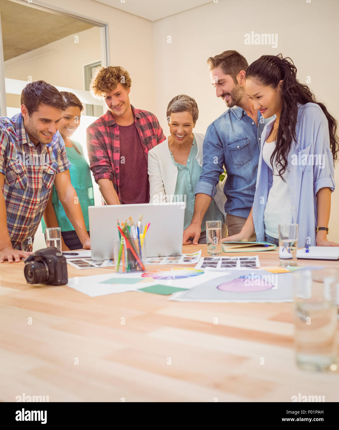 Happy creative business team using laptop in meeting Stock Photo