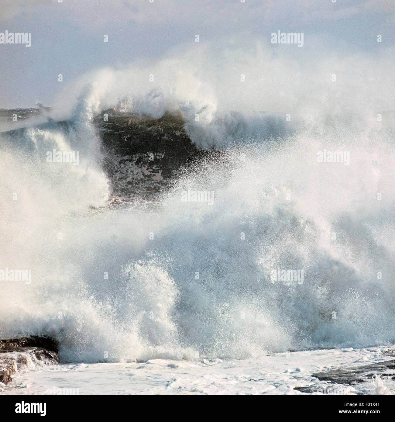 A wave breaking on the shore during rough seas. Stock Photo