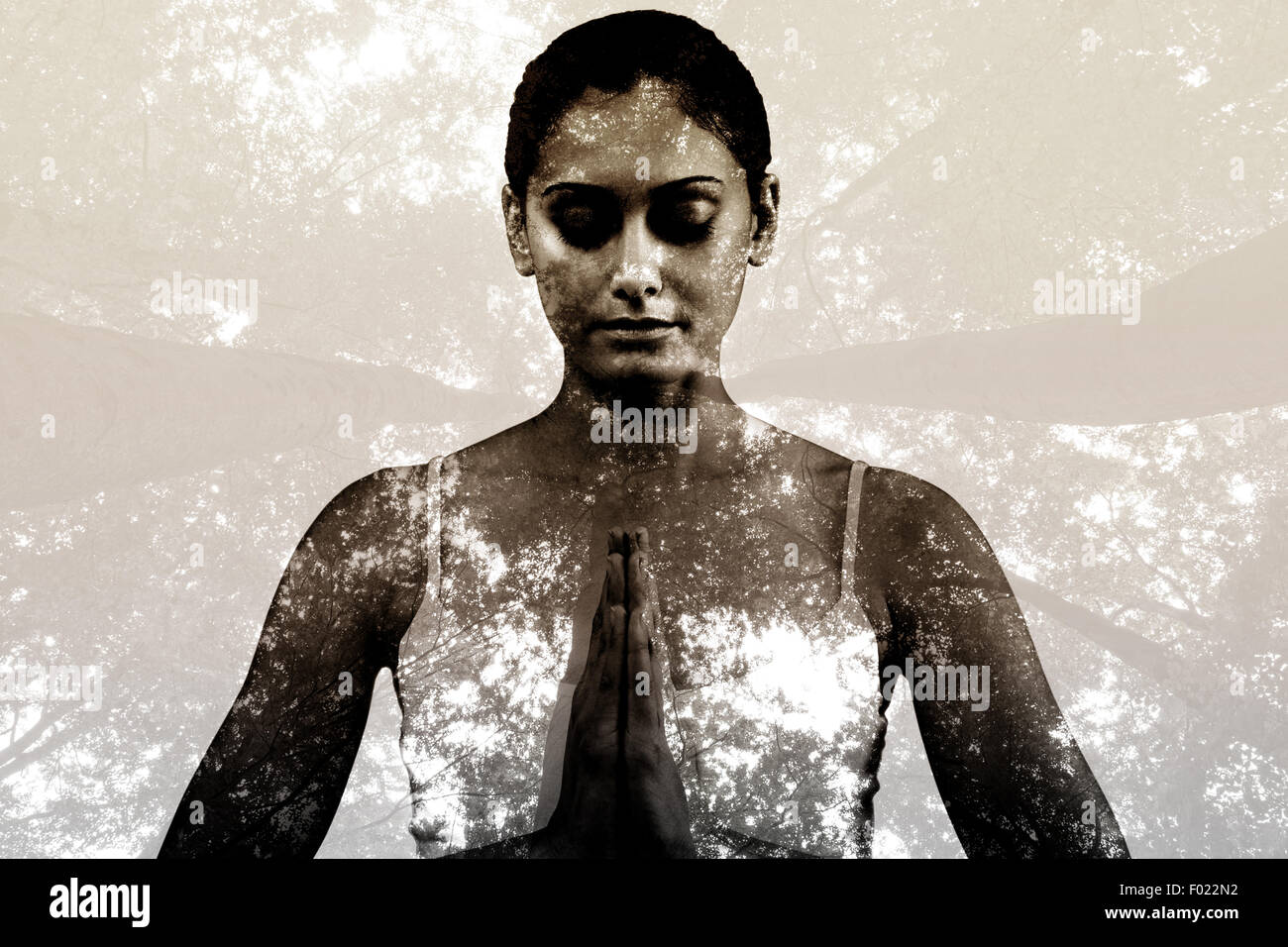 Composite image of peaceful woman in white sitting in lotus pose Stock Photo