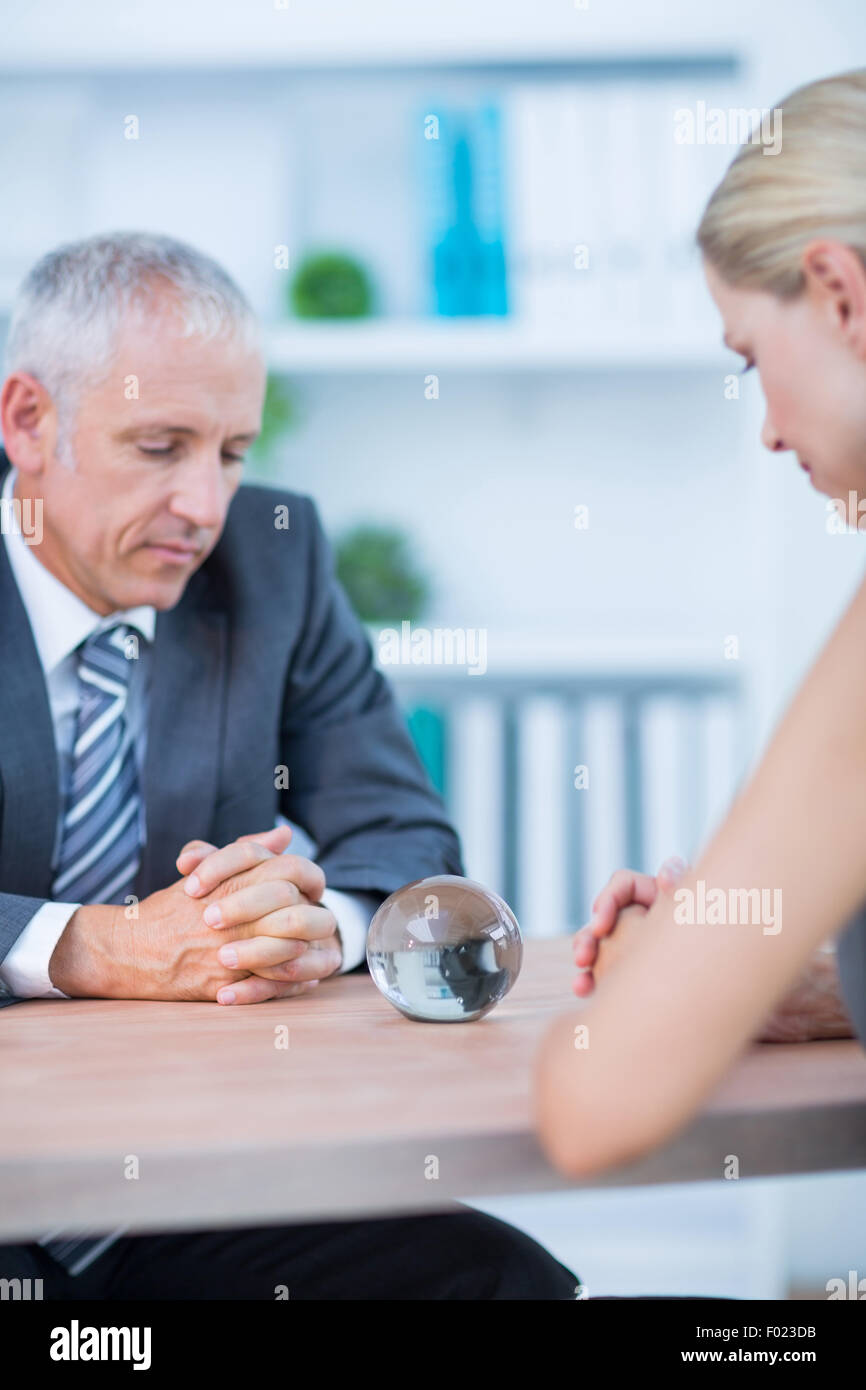 Business partners watching crystal ball Stock Photo - Alamy