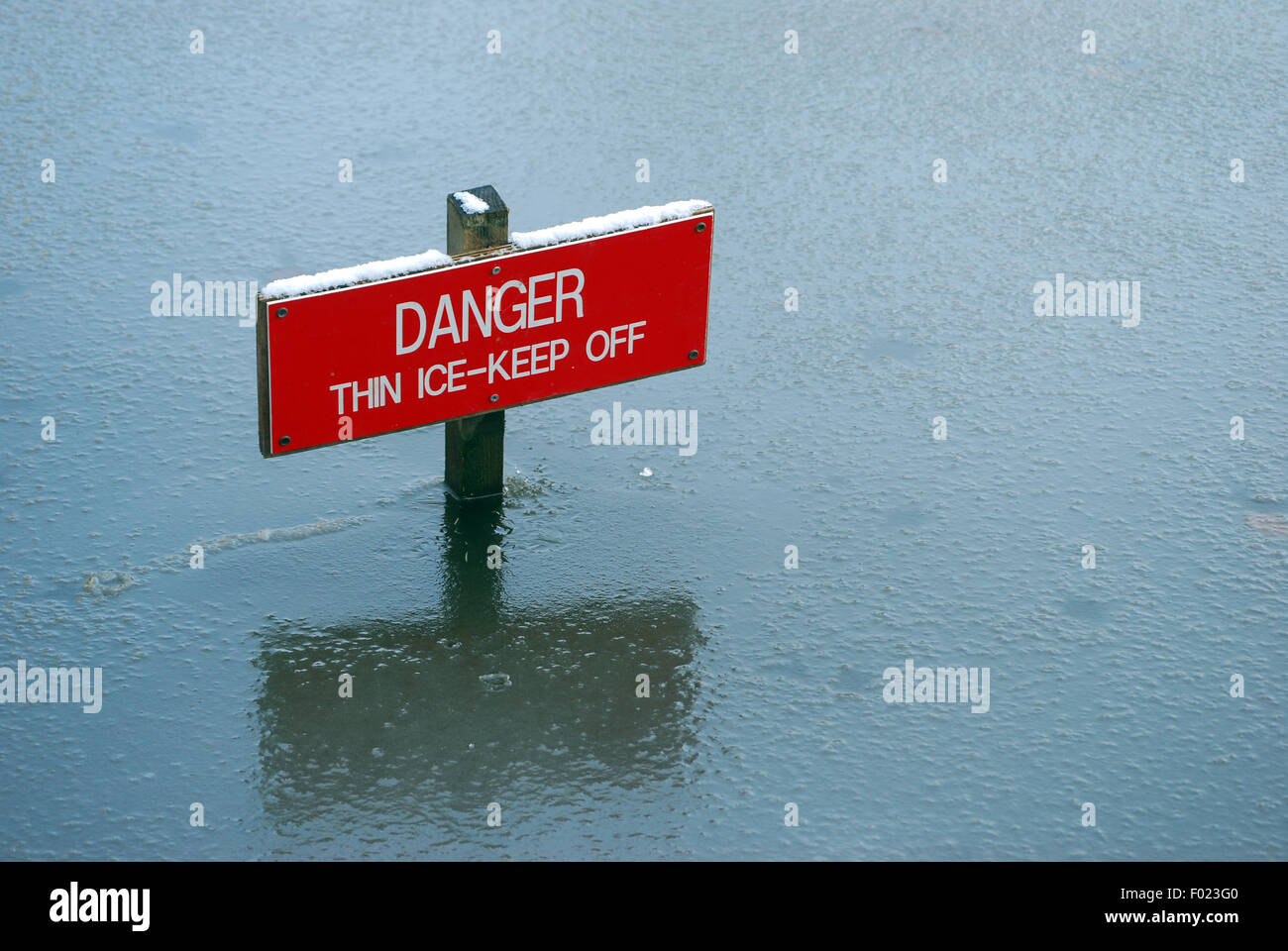 Cracking good warning ...  Danger Thin Ice Sign in lake Stock Photo