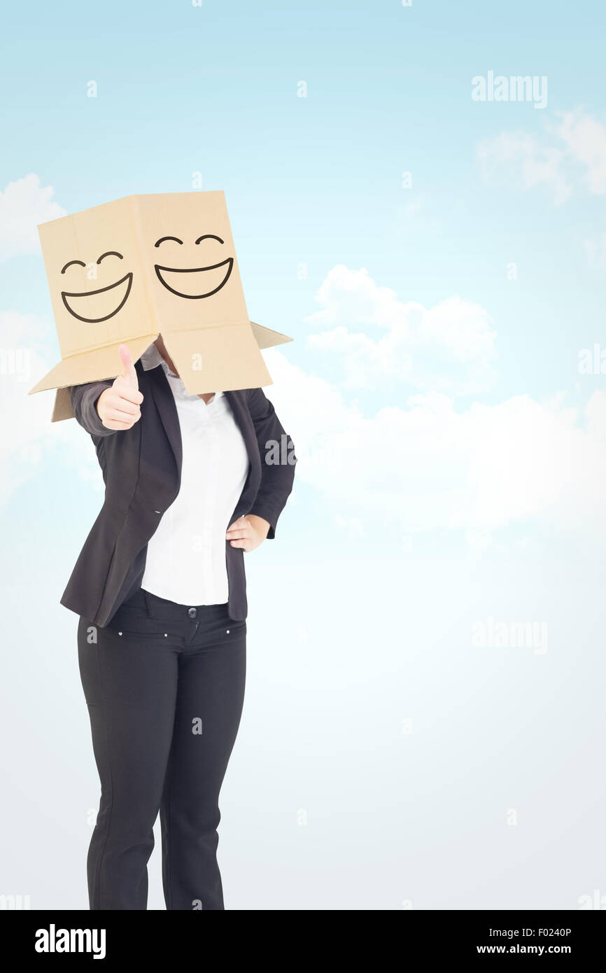 Composite image of businesswoman showing thumbs up with box over head Stock Photo