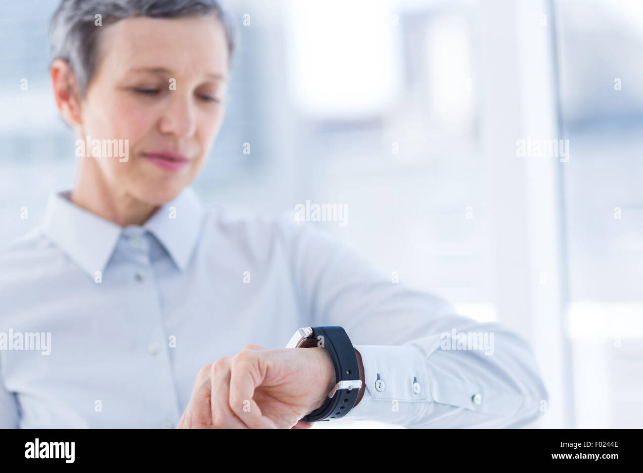 A businesswoman looking her smartwatch Stock Photo