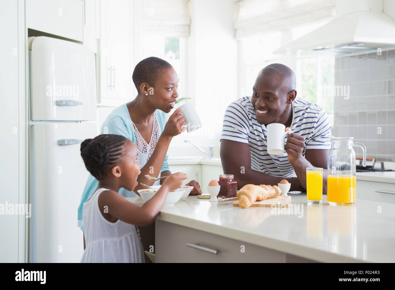 Happy family sitting and taking breakfast Stock Photo - Alamy