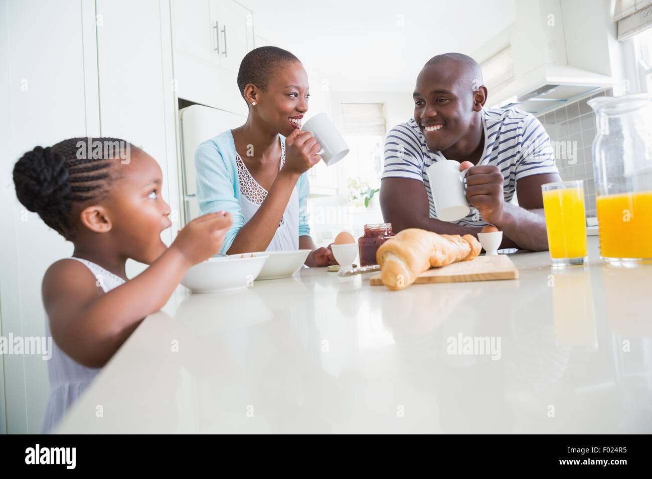 Happy family sitting and taking breakfast Stock Photo - Alamy