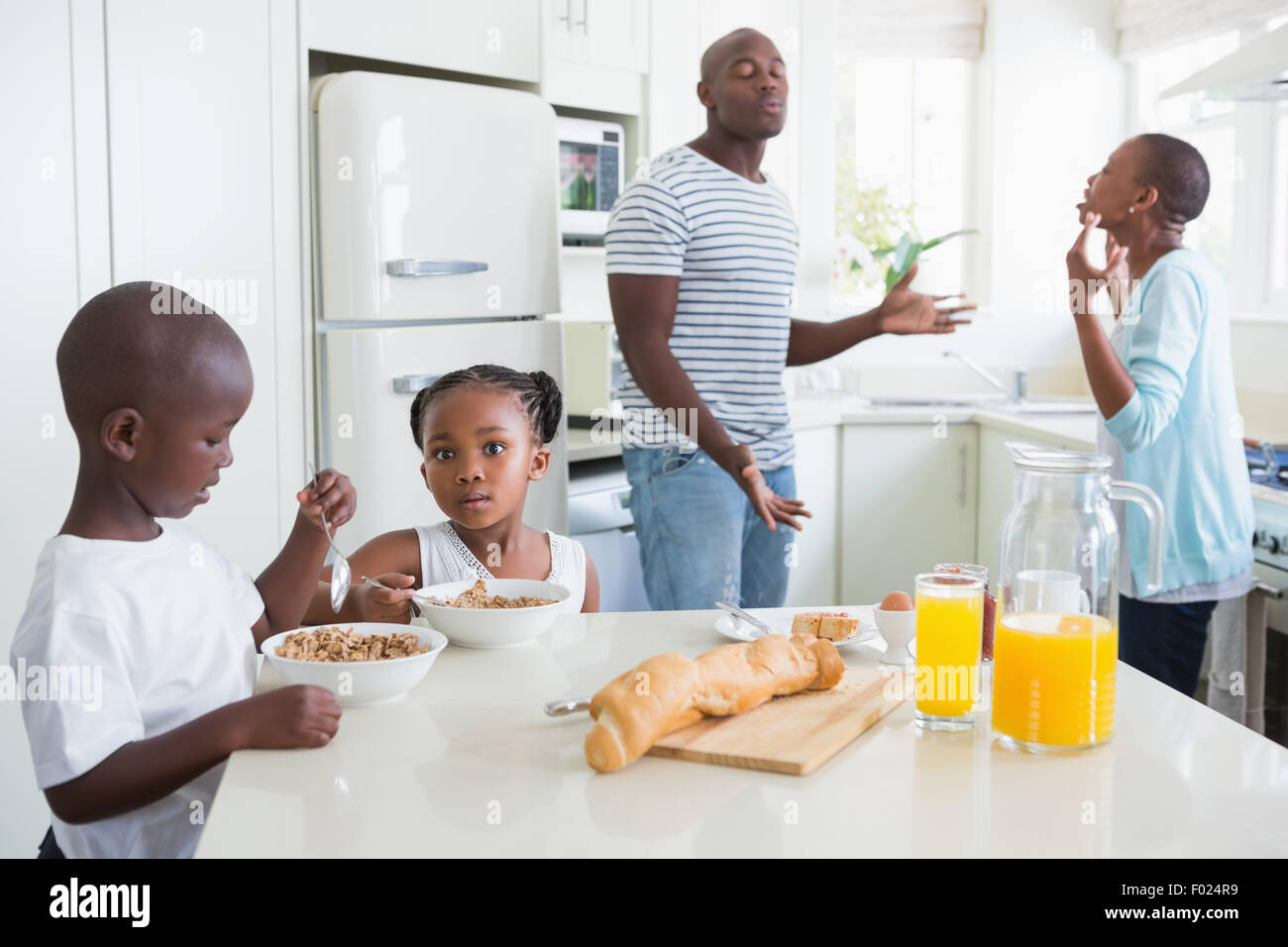 Happy family sitting and taking breakfast Stock Photo - Alamy