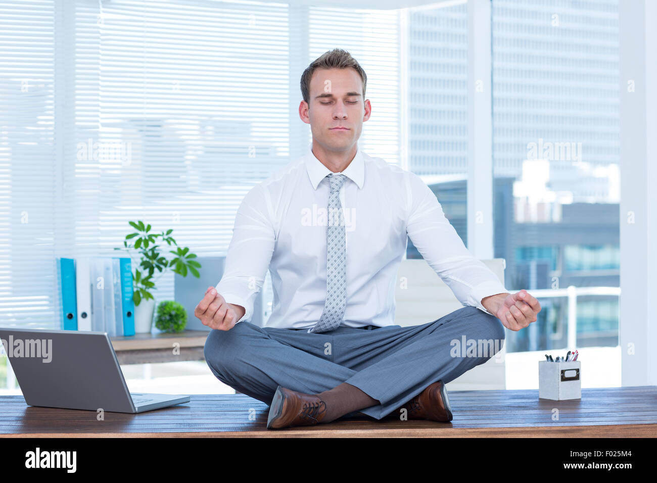 Zen businessman doing yoga meditation Stock Photo - Alamy
