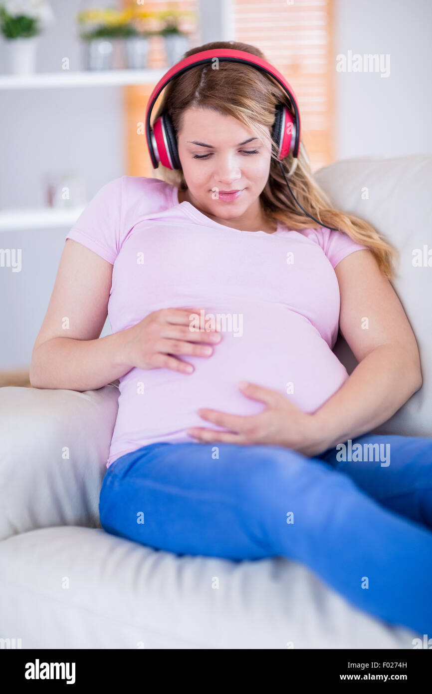 Pregnant woman listening music and touching her belly Stock Photo - Alamy