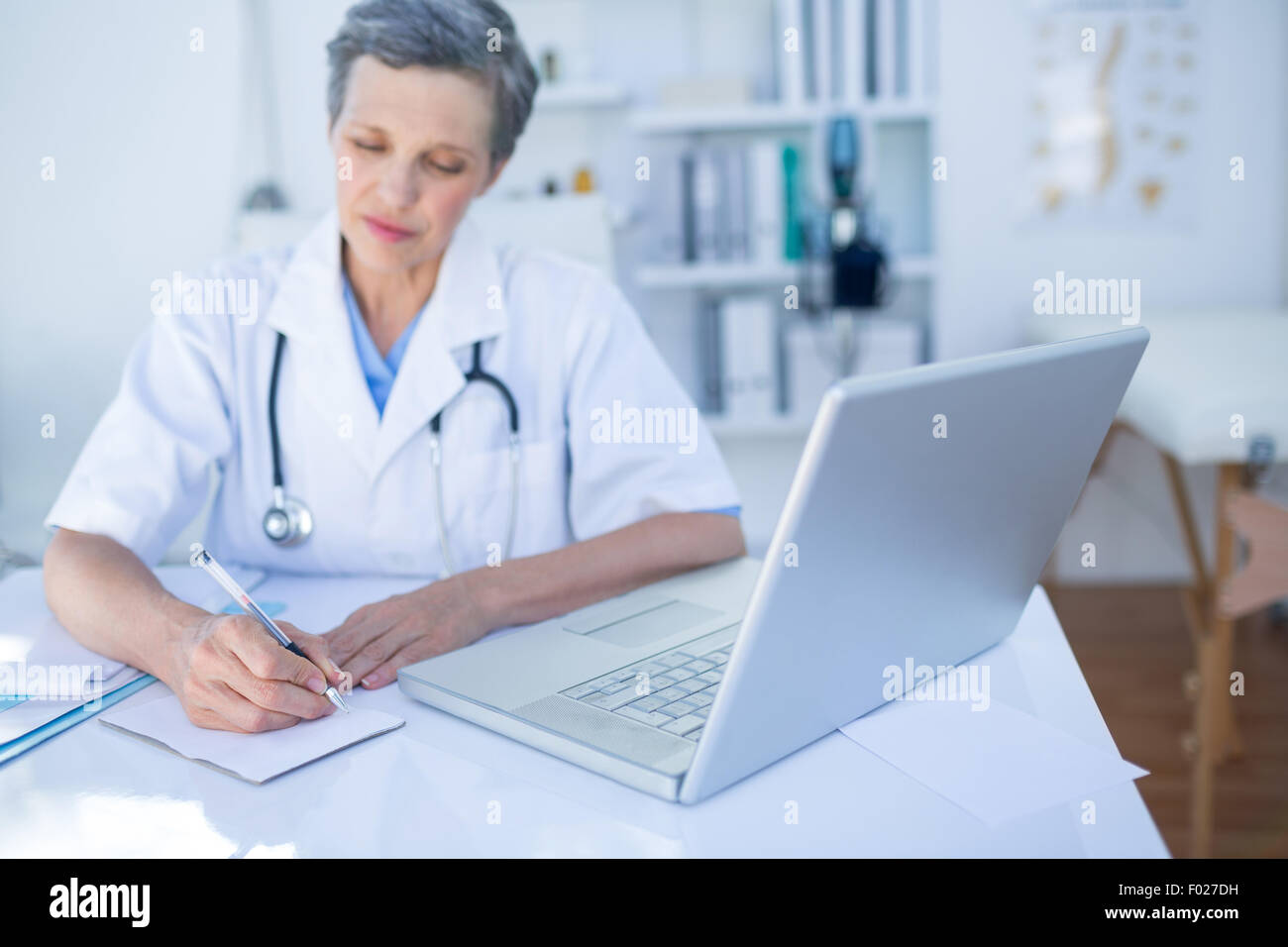 Female doctor writing on paper Stock Photo - Alamy