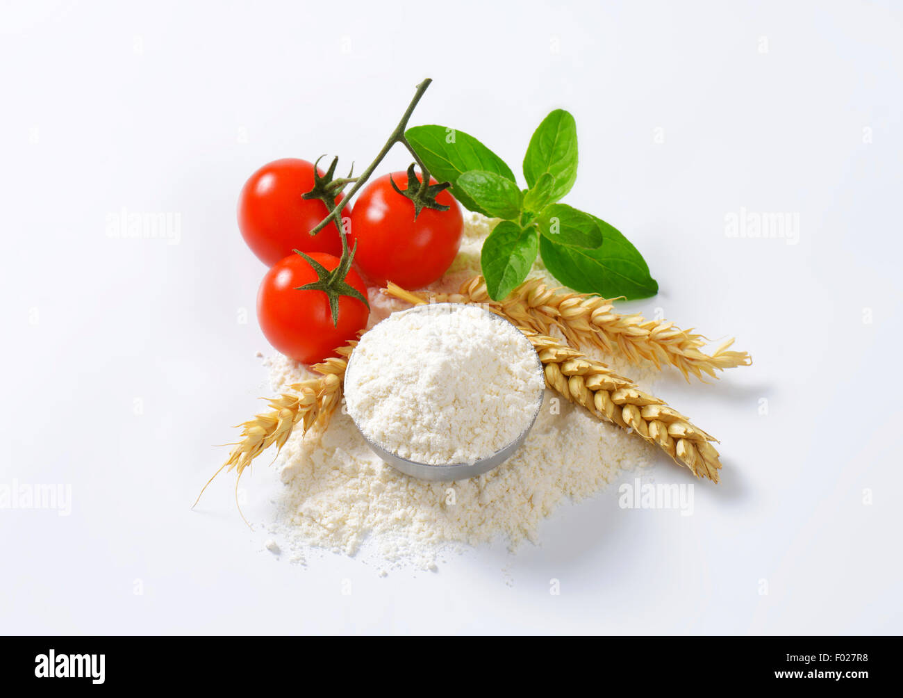 Bowl of finely ground flour, wheat ears and fresh tomatoes - still life Stock Photo