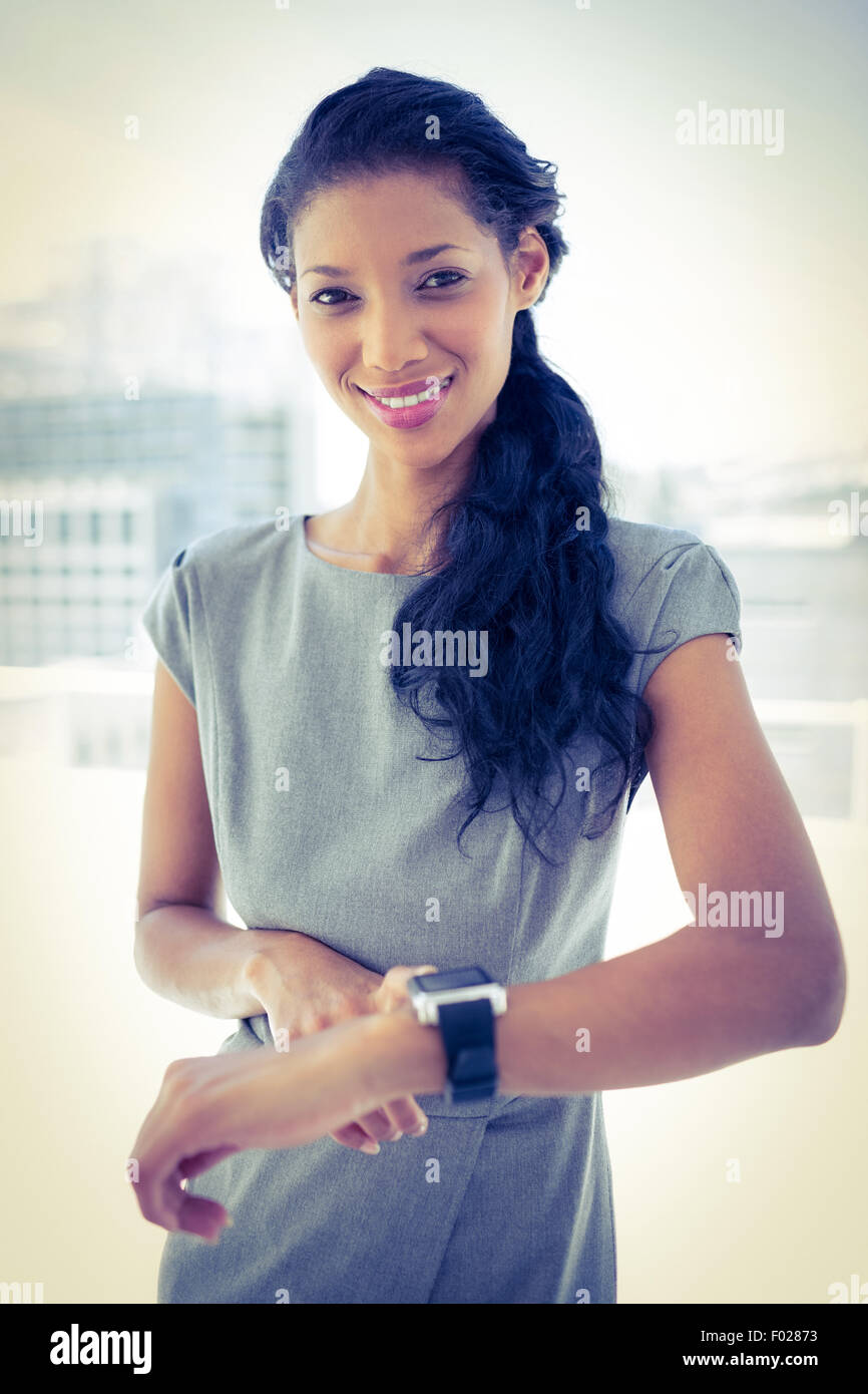 Smiling businesswoman using her smartwatch Stock Photo