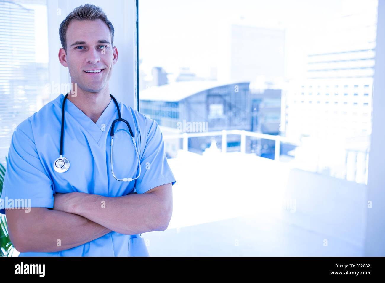Young smiling doctor crossed hi-res stock photography and images - Alamy