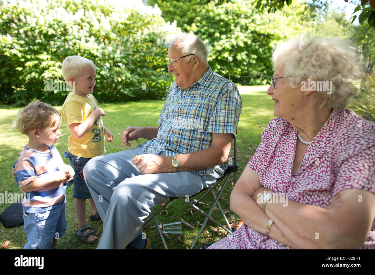 Grandparents, old age pensioners out in the sunshine, with younger generations of their family, England, UK Stock Photo