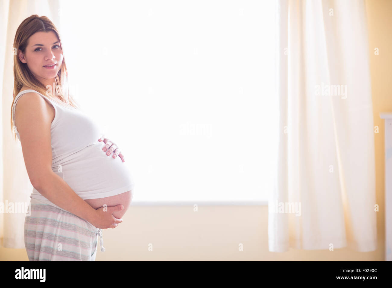 Pregnant woman holding her bump Stock Photo - Alamy