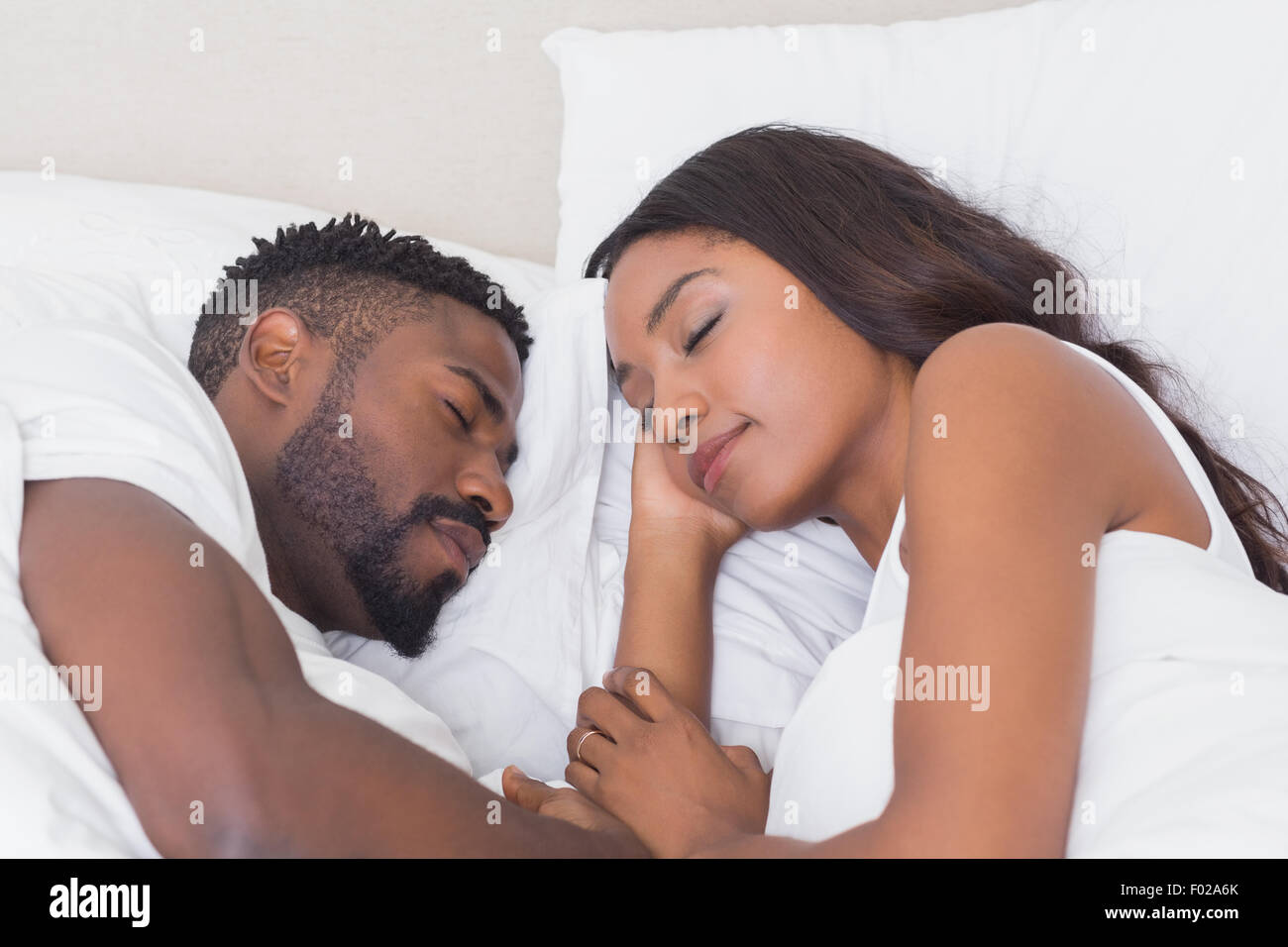 Happy couple sleeping in bed together Stock Photo - Alamy