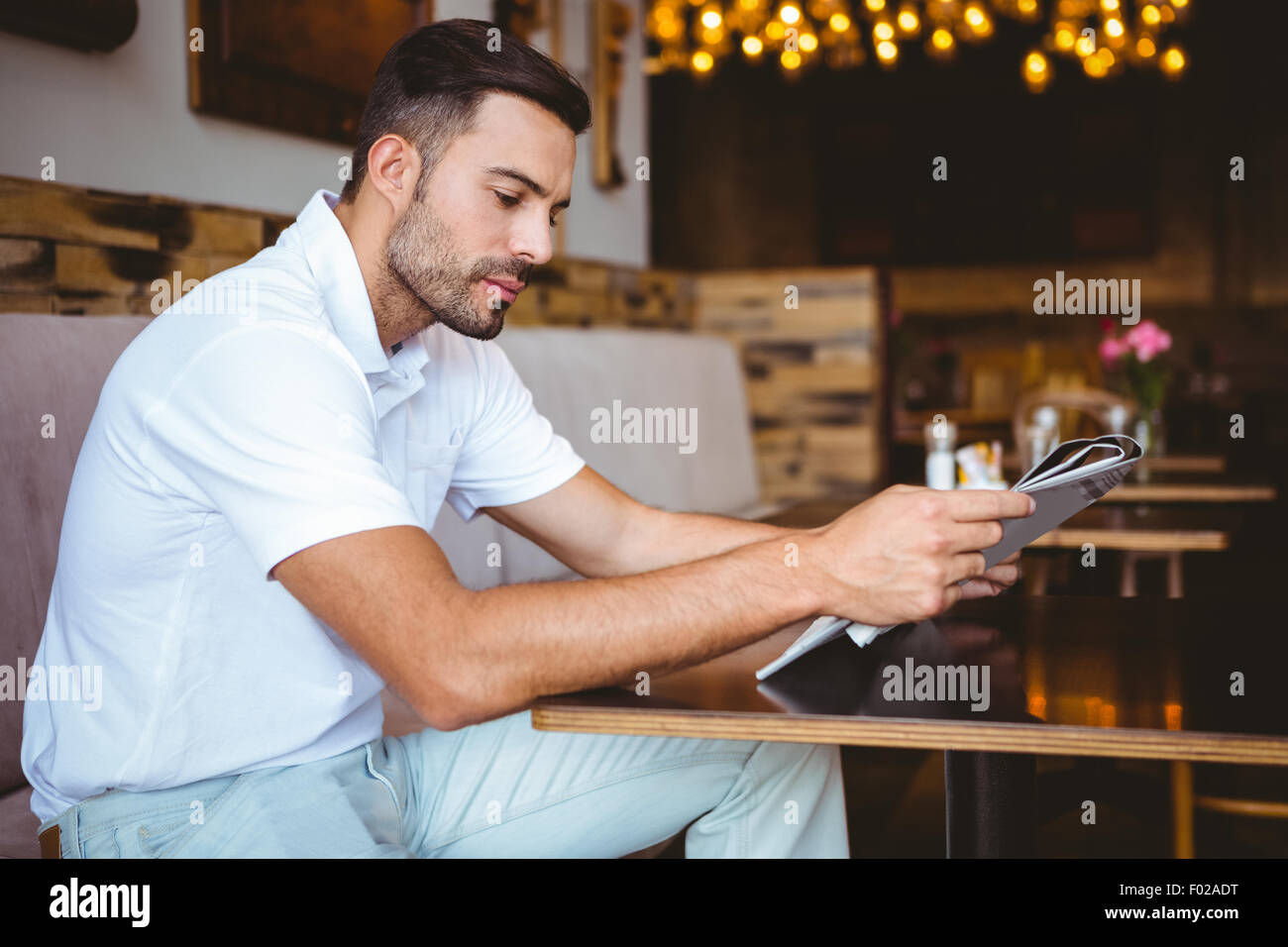 Young man reading a newspaper Stock Photo - Alamy