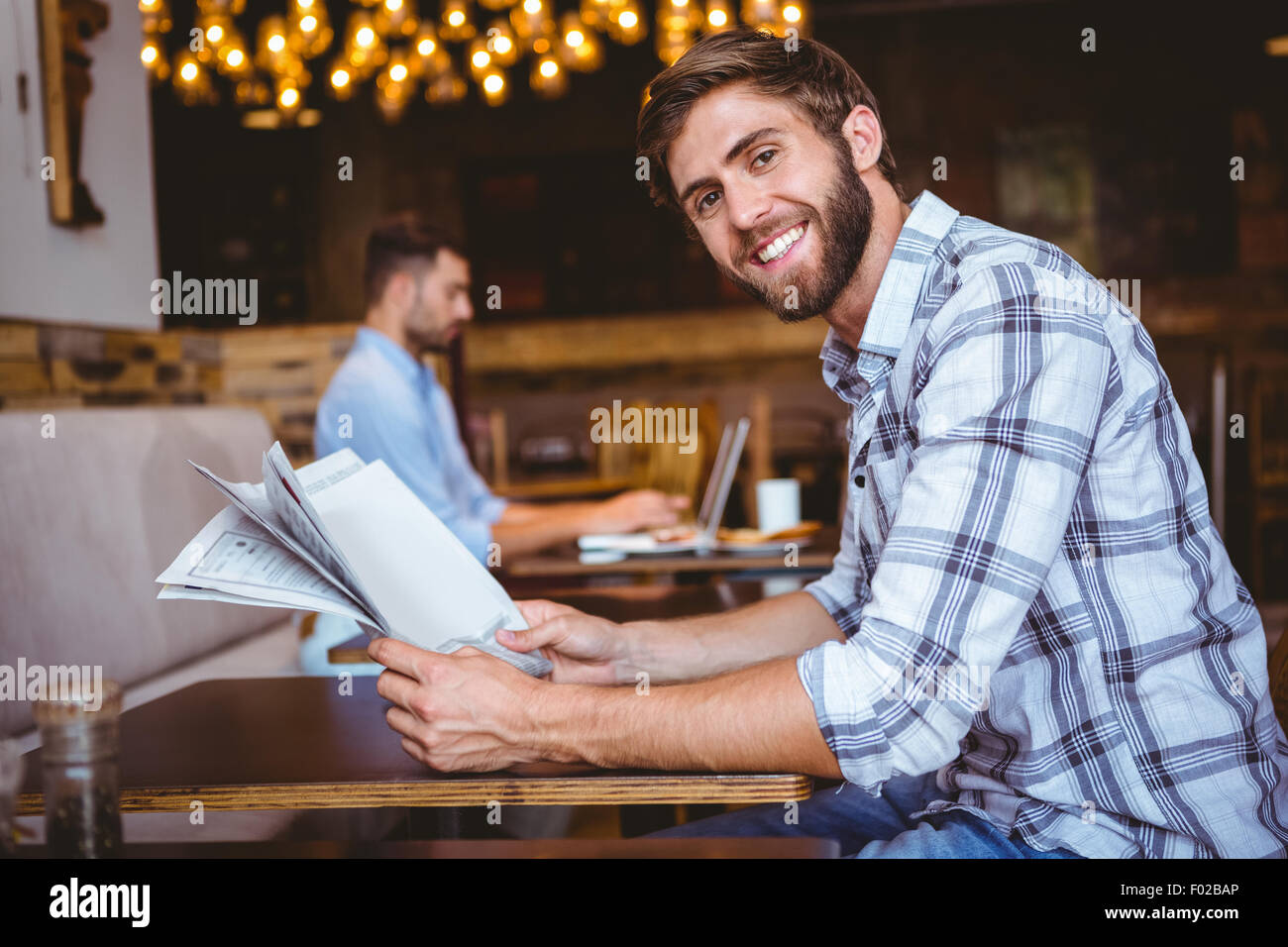 Young man reading a newspaper Stock Photo - Alamy