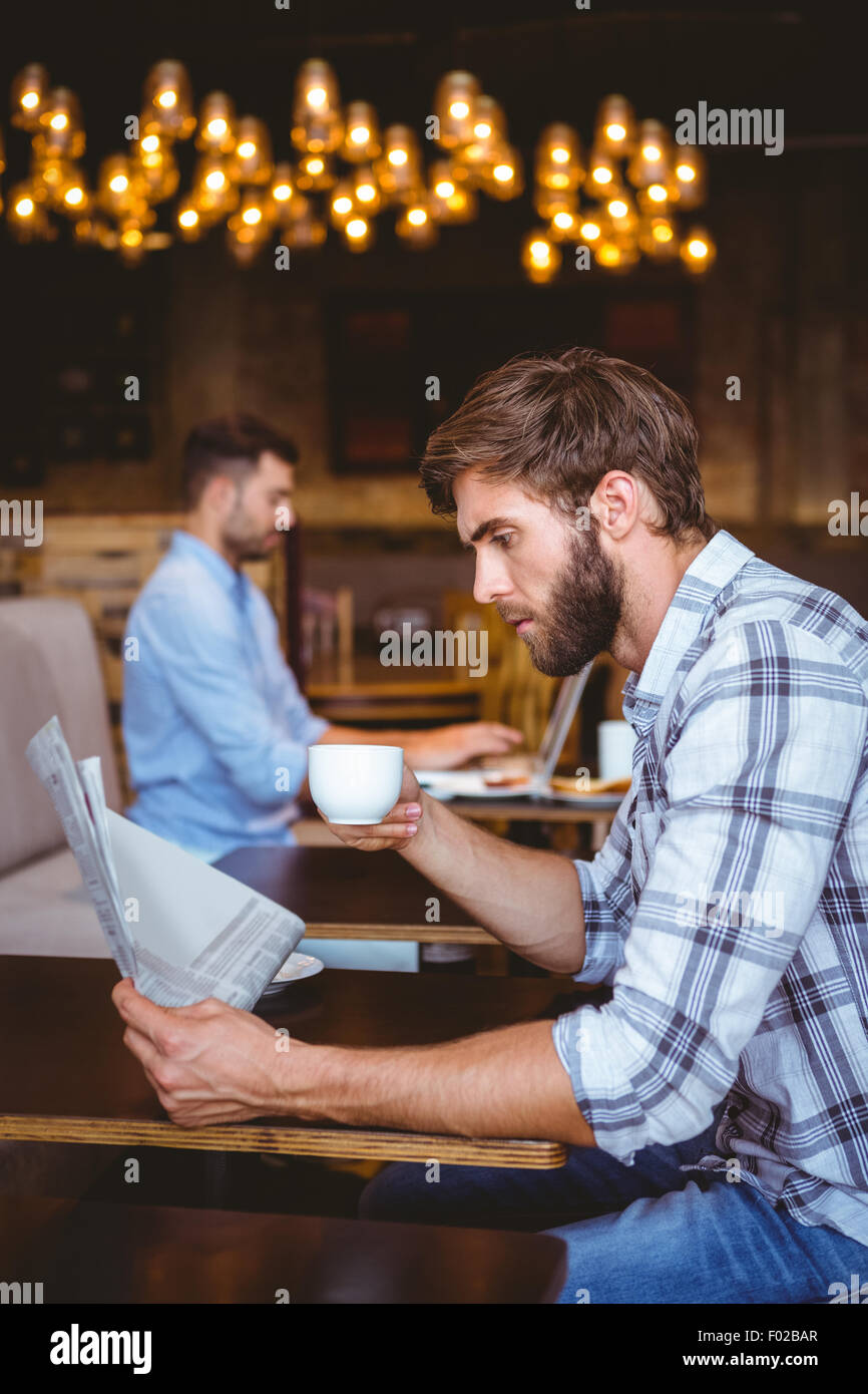 Young man reading a newspaper Stock Photo - Alamy
