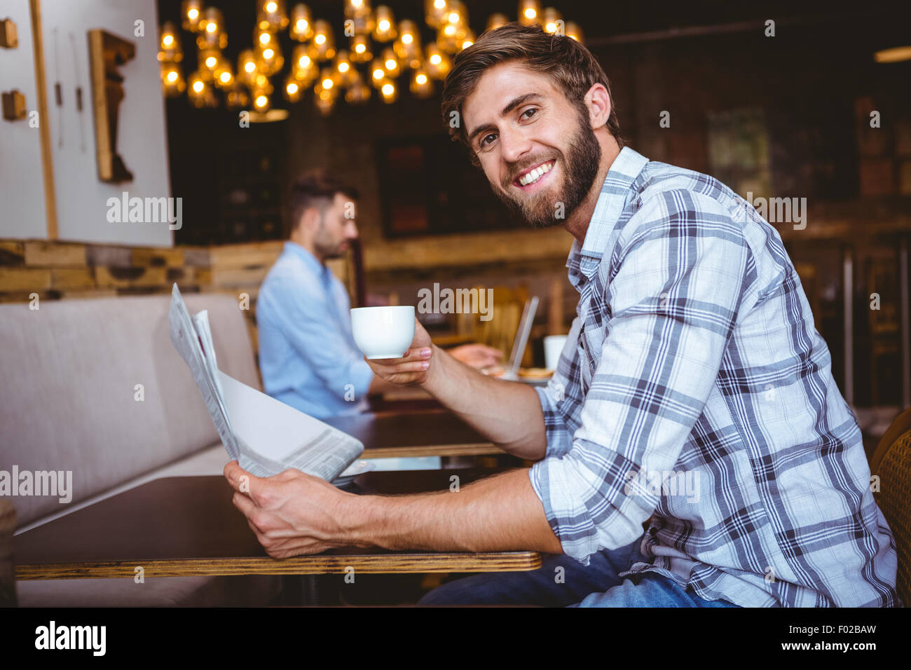 Young man reading a newspaper Stock Photo - Alamy