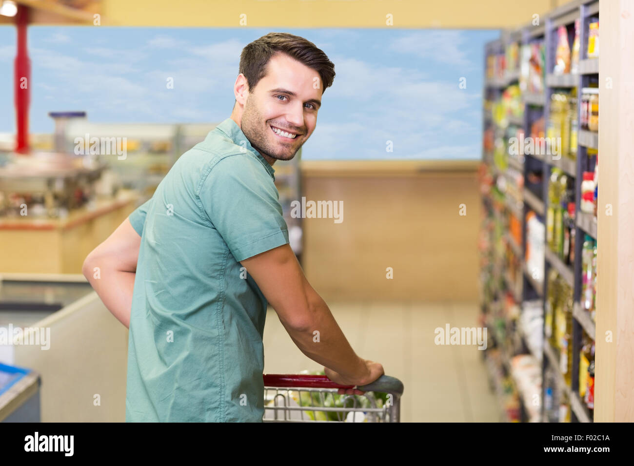Portrait of smiling man pushing his trolley in aisle Stock Photo - Alamy