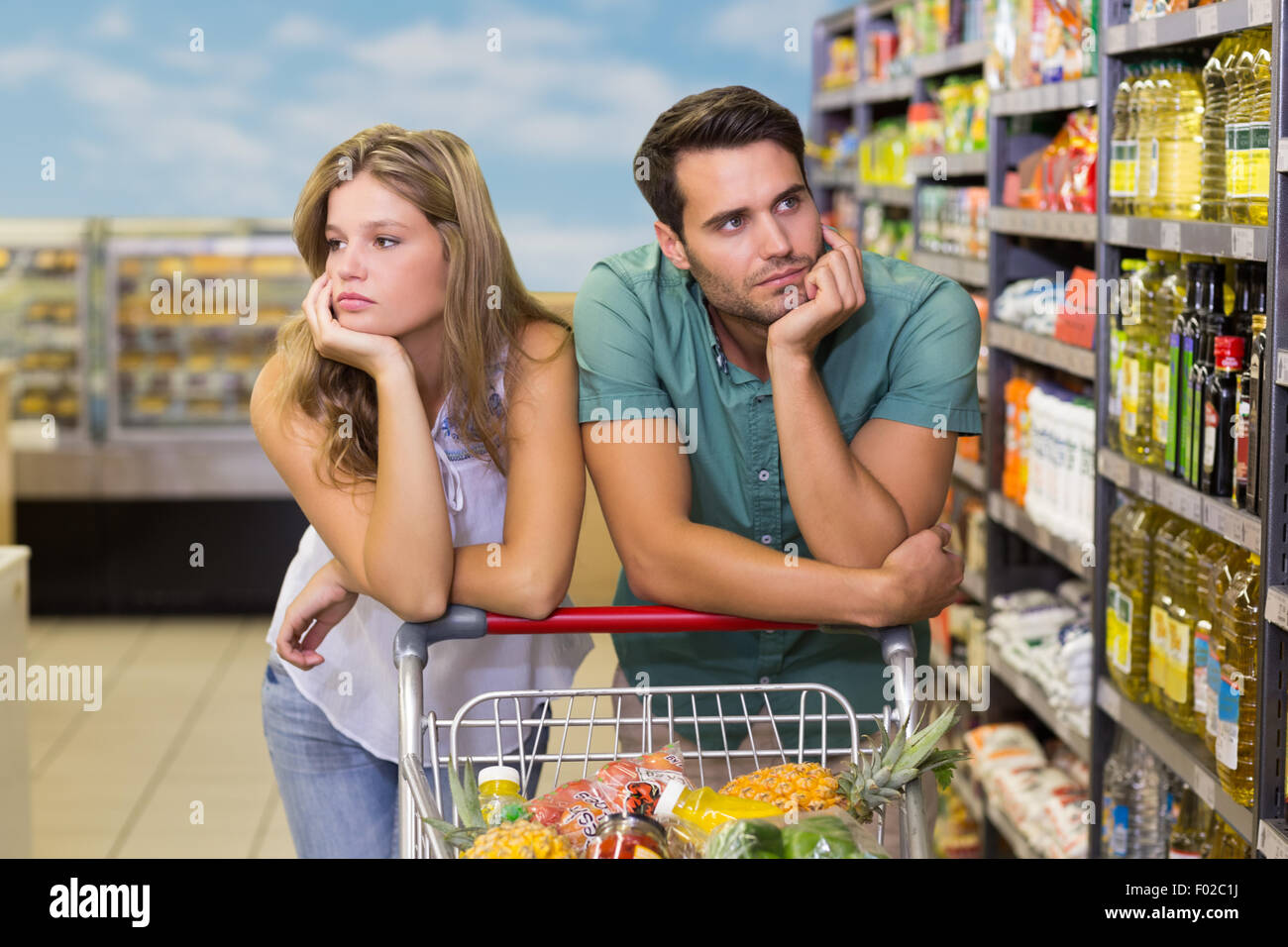 Serious brght couple buying food products Stock Photo