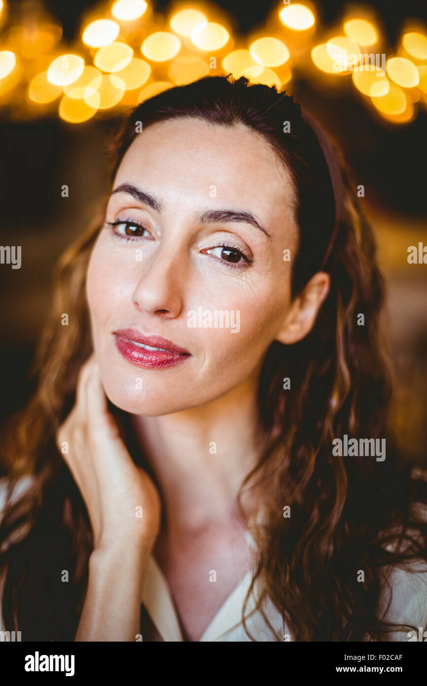 Close up of pretty brunette with hand under her chin looking at camera Stock Photo