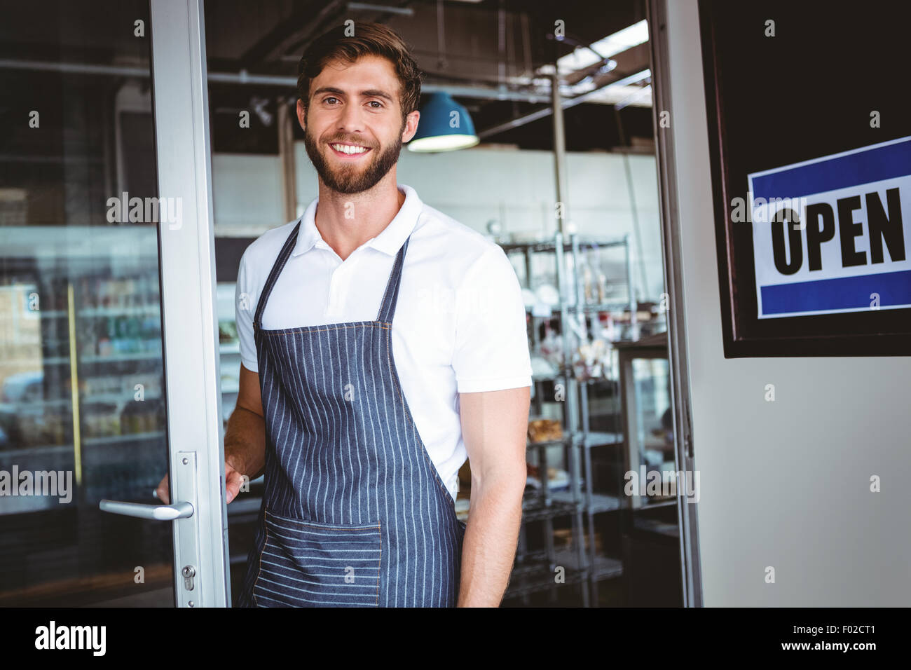 Smiling worker putting up open sign Stock Photo - Alamy